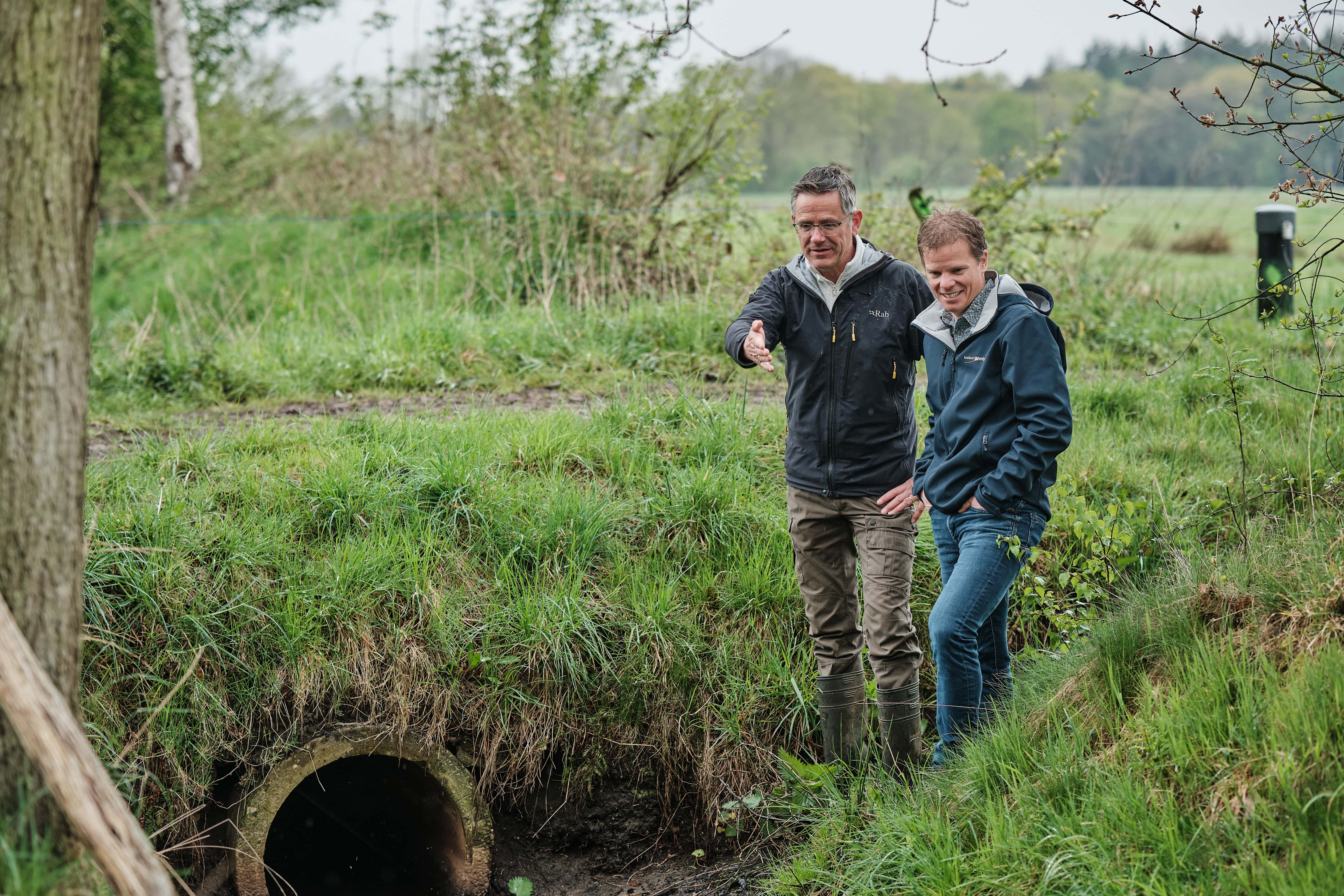 Martin de Haan en Jeroen Castelijns samen, Martin wijst naar water in het drinkwaterlandschap de Groote Heide