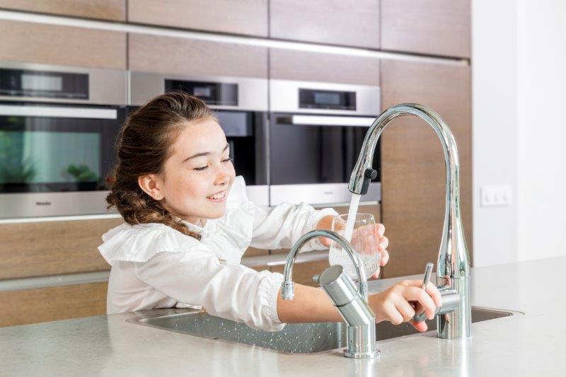 Meisje pakt water uit de kraan