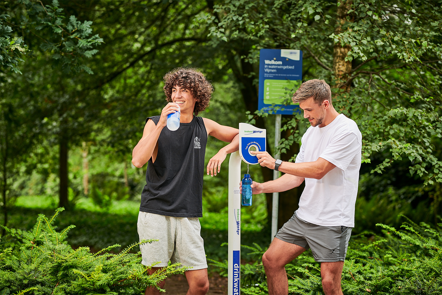 mannen vullen bidon bij watertappunt