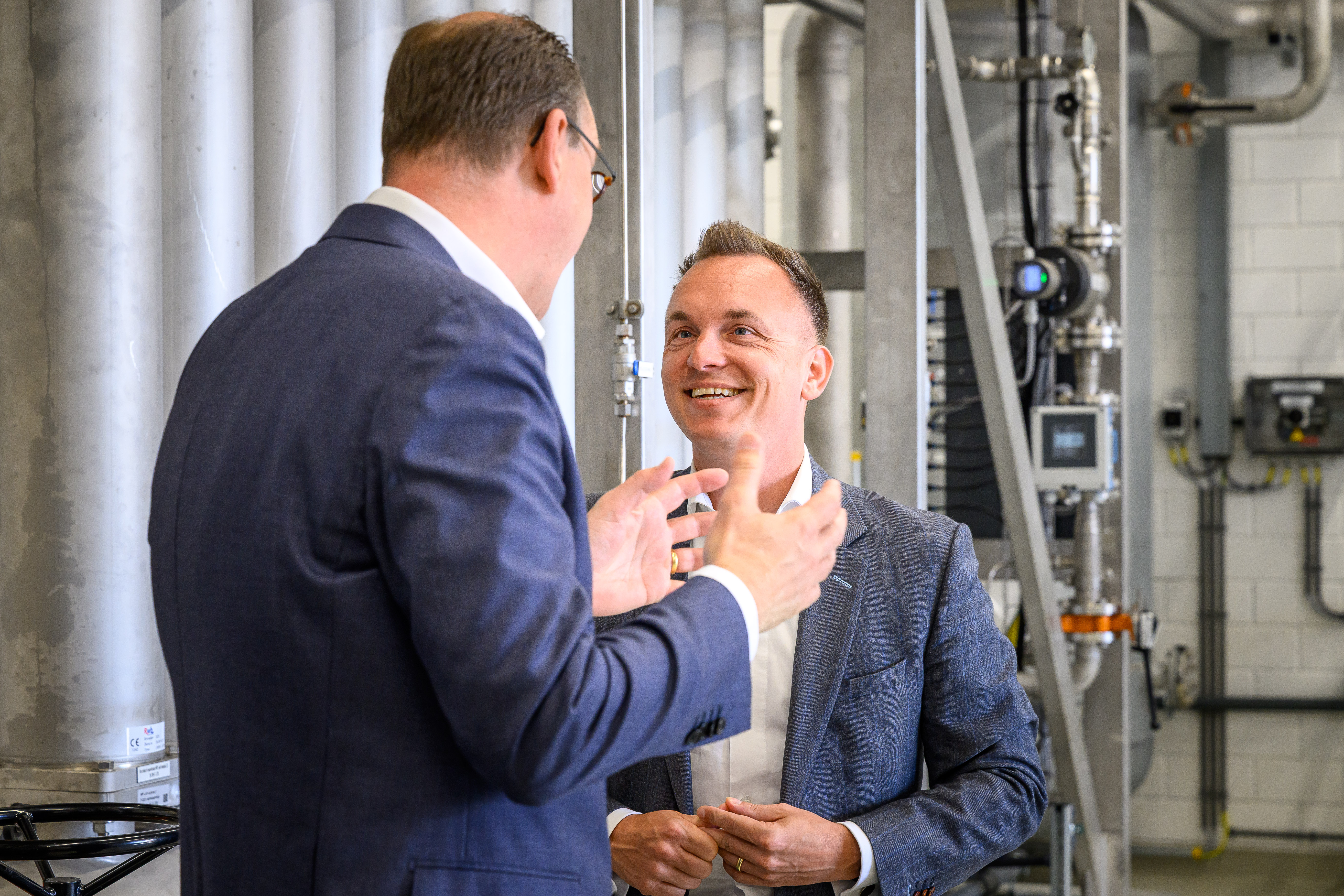 mannen in gesprek over spoelwaterterugwinunit in Loosbroek
