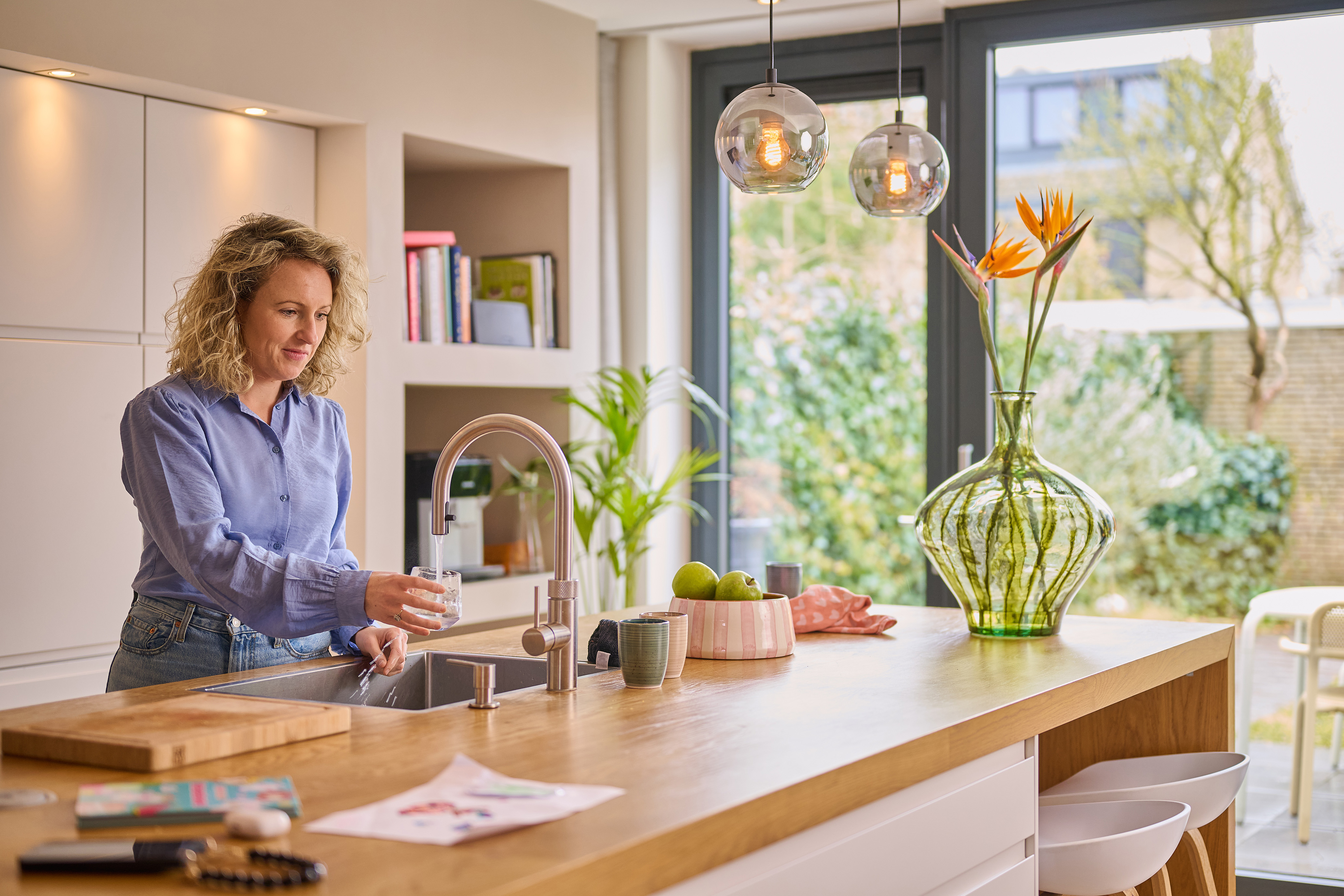 vrouw vult glas water uit kraan