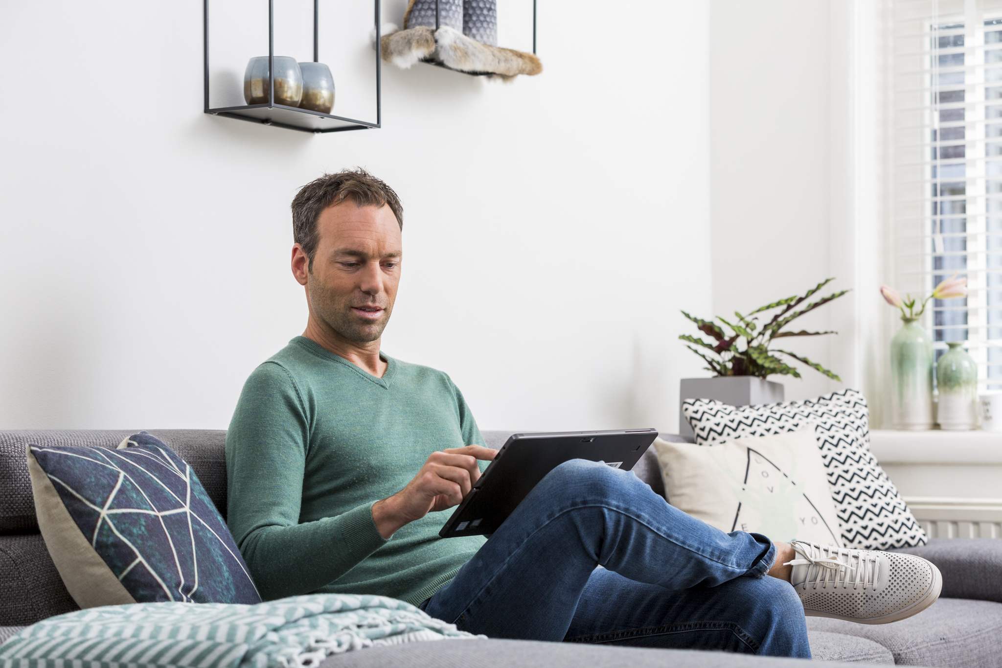 Man op bank met laptop