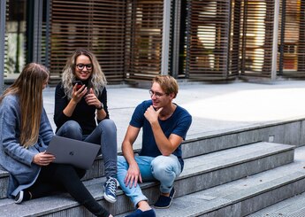 Studenten/werknemers praten buiten op de trap