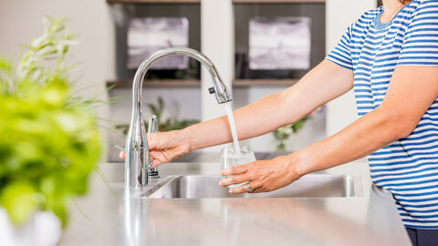 Vrouw vult glas met water