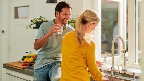 man en vrouw met glas water in keuken