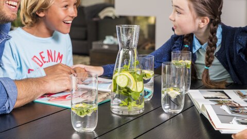 Karaf smaakwater staat op tafel bij gezin