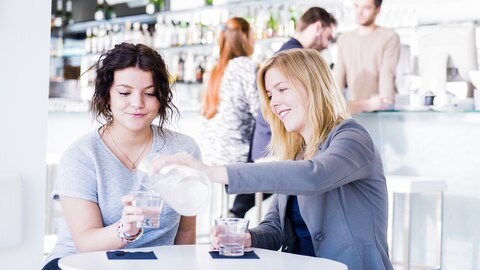 Vriendinnen drinken water in een restaurant