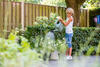 Jongetje geeft water in de tuin met gieter