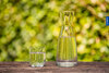 Karaf en glas kraanwater buiten in groene omgeving