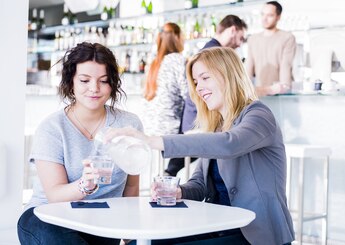 Vriendinnen drinken kraanwater in café