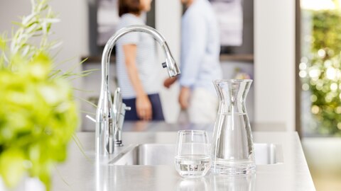 Glas en karaf bij kraan